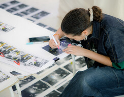 © Michaela Nagyidaiová Person seating at a table drawing.
