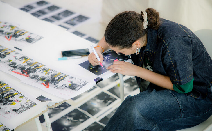 Person seating at a table drawing.